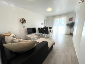 a living room with a couch and a table at Villa Annabella Beach Apartments - 100m from Sea in Cesarica