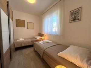 a room with two beds and a window at Villa Annabella Beach Apartments - 100m from Sea in Cesarica