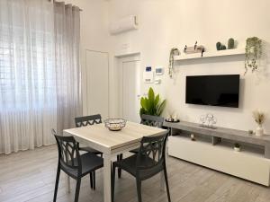 a dining room with a table and chairs and a tv at Room 28 in Conversano