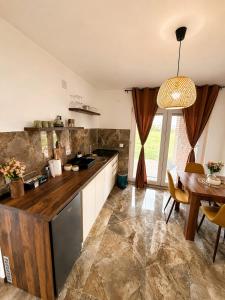 a large kitchen with a table and a dining room at Vila Dinka in Lipovac
