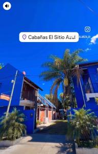 a screenshot of a text message about a blue building with a palm tree at El Sitio Azul Cabañas in Esquina