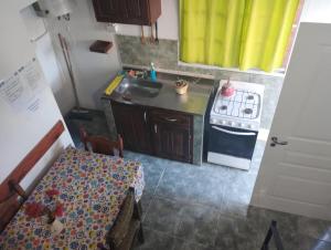 a small kitchen with a sink and a stove at El Sitio Azul Cabañas in Esquina