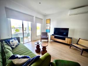 a living room with a green couch and a flat screen tv at Vivid Stays Chalkokondili in Nicosia