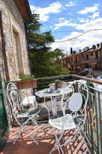 a patio with two chairs and a table on a balcony at Vintage House in Asciano