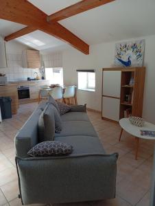 a living room with a couch and a kitchen at Charme - Centre historique de Die in Die
