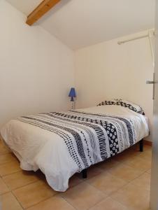 a bedroom with a bed with a black and white blanket at Charme - Centre historique de Die in Die