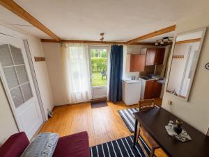 a living room with a table and a kitchen at Peaceful Cottage With Garden in Saulkrasti