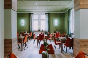 a restaurant with green walls and tables and red chairs at Sztuka Gór in Nowa Ruda