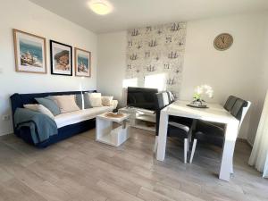 a living room with a couch and a table at Villa Annabella Beach Apartments - 100m from Sea in Cesarica