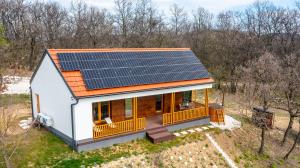 a small house with solar panels on the roof at Öreg-kő 1478 in Bajót