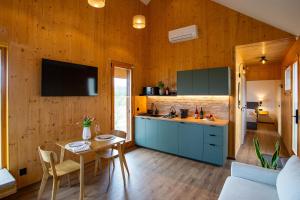 a kitchen with blue cabinets and a table in a room at Öreg-kő 1478 in Bajót