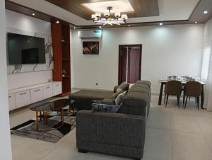 a living room with a couch and a table at T&J Harmony Lodge in Limbe