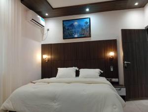a bedroom with a large bed with a wooden headboard at T&J Harmony Lodge in Limbe