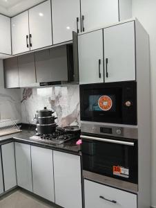 a kitchen with a stove and a microwave at T&J Harmony Lodge in Limbe