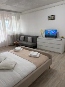 a bedroom with a large bed and a couch at Danuvia Studio 2 in Drobeta-Turnu Severin