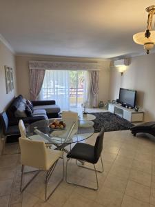 a living room with a couch and a table and chairs at Sol Apartments in Vilamoura