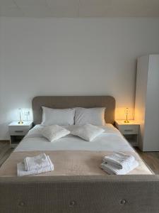 a bedroom with a large bed with two towels on it at Danuvia Studio 2 in Drobeta-Turnu Severin