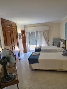a hotel room with two beds and a fan at Sol Apartments in Vilamoura