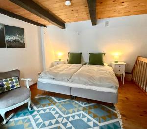 a bedroom with a large bed and a chair at Historisches Ganghaus "Bluebelle" in Lübeck