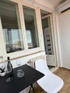 a table and white chairs in a room with windows at Danuvia Studio 2 in Drobeta-Turnu Severin