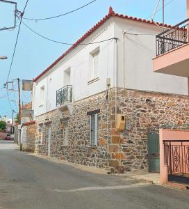 a stone building on the side of a street at Summerstone Cottage in Aliveri