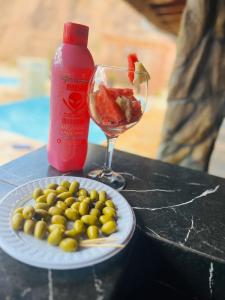 a plate of olives and a bottle of wine and a glass at Chácara sonho meu in Jacutinga +66 photos