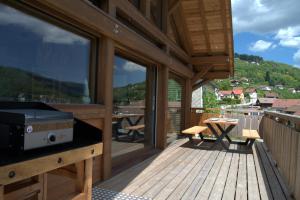 a balcony with a grill on a wooden deck at Le Bois Lumen 1 in La Bresse