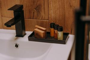 a tray with bottles of essential oils on a bathroom sink at Sztuka Gór in Nowa Ruda +36 photos
