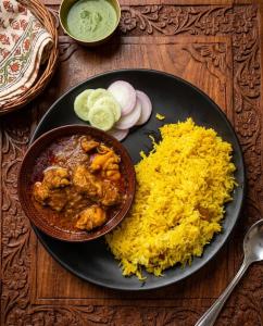 a plate of food with chicken and rice on a table at Hotel DG Residency in Guwahati