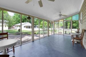 an empty screened porch with glass doors and a ceiling fan at Derby Dreams llc in Clarksville