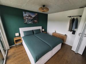 a bedroom with a large bed with a green wall at Luxury Home JuNa in Aarau