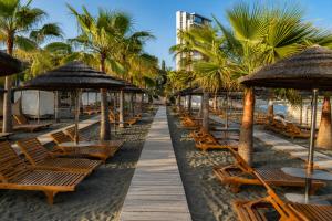 a row of chairs and umbrellas on a beach at Maison Amalthea in Limassol