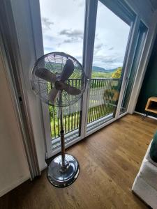 a fan in front of a balcony with a window at Luxury Home JuNa in Aarau