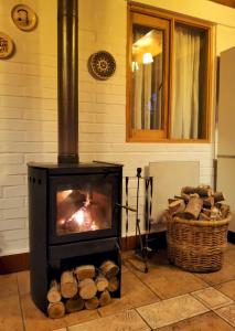 a stove in a room with a pile of logs at Casa Emiluz in La Serena