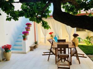 a patio with a table and chairs and flowers at Casa VersoMare Rooftop in Gagliano del Capo