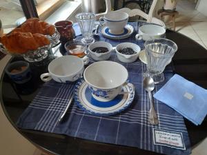 a table with cups and dishes on a blue table cloth at Chez Is-Mi in Chauriat