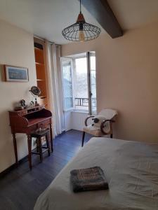 a bedroom with a bed and a desk and a window at Chez Is-Mi in Chauriat