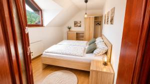 a small bedroom with a bed and a window at Apartmán pod Skalou in Vysoká nad Kysucou