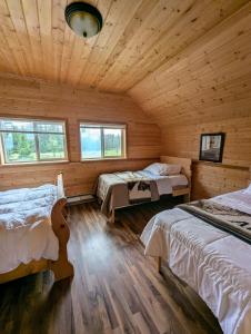 a bedroom with two beds in a log cabin at NV Mountainview Chalets & RV Resort in McBride