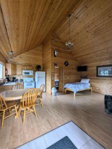 a kitchen and a dining room with a table and chairs at NV Mountainview Chalets & RV Resort in McBride