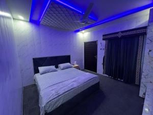 a bedroom with a large bed with a blue light at Ajk bed & Breakfast in Gura Gujarān +5 photos