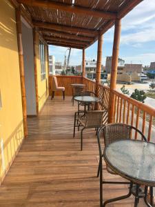 a porch with tables and chairs on a balcony at Flamante Atardecer in Paracas