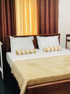 a bedroom with a bed with two pillows at Mountain Lodge Ella in Bandarawela