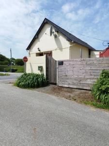 a white house with a wooden fence and a stop sign at La p'tite maison in Bordeaux-Saint-Clair