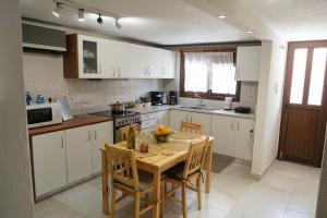 a kitchen with a wooden table with chairs and a table and a table at Evi's House in Kandia