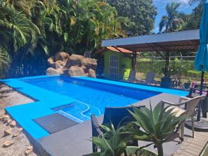a swimming pool in a backyard with a waterfall at La Esmeralda Villa in Orotina