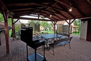 a patio with a table and a bench and a grill at Mazurska Tajemnica 1 in Łoje