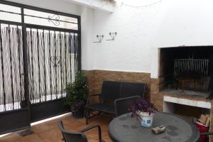 a patio with a table and chairs and a fireplace at El patio de Marcos in La Recueja
