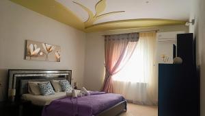 a bedroom with a bed with purple sheets and a window at Lyra's house in Skiathos