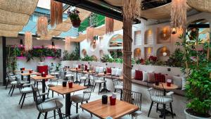 a restaurant with wooden tables and chairs and plants at Viva Rooms in Istanbul